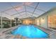 Sparkling pool with a screened enclosure, surrounded by a paved deck and well-maintained landscaping at 13375 Newcastle Ave, Spring Hill, FL 34609