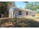 Backyard view showcases the home's exterior, green grass, and fenced-in yard at 1344 S Michigan Ave, Clearwater, FL 33756
