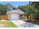Inviting single-story home with a two-car garage, complemented by lush landscaping and a welcoming front porch at 1344 S Michigan Ave, Clearwater, FL 33756