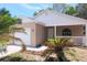 Close up shot of the exterior featuring a quaint front porch and neatly landscaped front yard with mature palms at 1344 S Michigan Ave, Clearwater, FL 33756