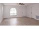 Bright and airy living room featuring neutral paint, updated flooring, a ceiling fan, and natural light at 1344 S Michigan Ave, Clearwater, FL 33756
