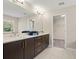 Bathroom with dual vanity, modern fixtures, tile flooring, and walk-in closet at 1520 W Fig St, Tampa, FL 33606