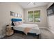 Bright bedroom featuring a cozy blue bed frame, plush carpet, and a window offering outdoor views at 1520 W Fig St, Tampa, FL 33606