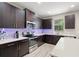 Well-lit kitchen featuring dark cabinetry, stainless steel appliances, and white countertops at 1520 W Fig St, Tampa, FL 33606