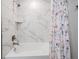 Detailed view of a shower with a white tub and decorative floral shower curtain at 1543 W Cass St, Tampa, FL 33606