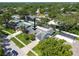 Birds-eye view of a residence featuring a pool enclosure, mature trees, and a well-kept lawn at 1622 El Tair Trl, Clearwater, FL 33765