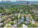 Aerial view showcases a home near Tampa and St. Petersburg with a pool and screened enclosure at 1622 El Tair Trl, Clearwater, FL 33765