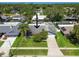 An aerial view of a single-Gathering home with a well-manicured lawn, mature trees, and a long driveway at 1622 El Tair Trl, Clearwater, FL 33765