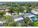Overhead shot showcases a home with a pool, screened enclosure, and mature landscaping in a quiet neighborhood at 1622 El Tair Trl, Clearwater, FL 33765