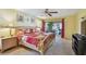 Warm bedroom with a cozy bed and access to outdoor patio at 1622 El Tair Trl, Clearwater, FL 33765