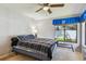 Cozy bedroom featuring ceiling fan and view to green lawn at 1622 El Tair Trl, Clearwater, FL 33765