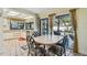 Dining area with an access to the pool and kitchen with adjacent seating and a serene view of the outdoors at 1622 El Tair Trl, Clearwater, FL 33765