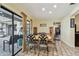 Sunlit dining room features sliding glass doors, stylish decor, and comfortable seating for entertaining guests at 1622 El Tair Trl, Clearwater, FL 33765