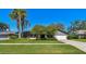 Well-maintained single-story home featuring lush landscaping, a green lawn, and an attached two-car garage at 1622 El Tair Trl, Clearwater, FL 33765