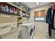 Functional laundry room featuring storage shelves, utility sink, and washer/dryer at 1622 El Tair Trl, Clearwater, FL 33765