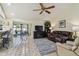 Bright living room features tile floors, ceiling fan, and seamless transition to outdoor dining at 1622 El Tair Trl, Clearwater, FL 33765