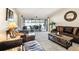 Spacious living room featuring leather furniture, neutral carpet and views of the screened in patio at 1622 El Tair Trl, Clearwater, FL 33765