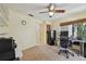 This home office features neutral walls and carpet, a ceiling fan, and a window with views of the backyard at 1622 El Tair Trl, Clearwater, FL 33765