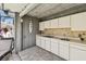The outdoor kitchen features a sink, cabinets, tile backsplash, and concrete ceilings that merges the indoor and outdoor at 1622 El Tair Trl, Clearwater, FL 33765