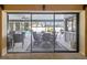 View of the screened-in lanai with patio furniture from inside the house, through a sliding glass door at 1622 El Tair Trl, Clearwater, FL 33765