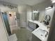 Bright bathroom featuring double sinks with white counters and cabinets, modern fixtures, and decorative wall accents at 18108 Ashton Park Way, Tampa, FL 33647