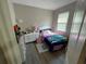 Bright bedroom with a white bed, colorful bedding, wood-look flooring, and a window for natural light at 18108 Ashton Park Way, Tampa, FL 33647
