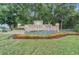 Hunter's Green community sign surrounded by lush landscaping and colorful flower beds at 18108 Ashton Park Way, Tampa, FL 33647