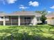 Charming home with a screened patio, lush lawn, and mature landscaping offers a serene backyard setting at 18108 Ashton Park Way, Tampa, FL 33647
