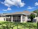 Lovely home with a screened patio, green lawn, and trees offering a tranquil backyard retreat at 18108 Ashton Park Way, Tampa, FL 33647
