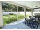A covered patio offers a relaxing outdoor space with views of the lush green lawn and mature trees at 18108 Ashton Park Way, Tampa, FL 33647