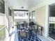 Covered patio with comfortable seating, outdoor grill, and view of backyard and screened-in pool at 18108 Ashton Park Way, Tampa, FL 33647