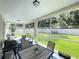 A screened patio with a table, chairs, and a grill offering backyard views for outdoor enjoyment at 18108 Ashton Park Way, Tampa, FL 33647