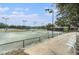 Well-maintained tennis courts with lighting, benches, and spectator seating for community enjoyment at 18108 Ashton Park Way, Tampa, FL 33647