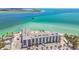 Aerial view of a beachfront condominium community with parking, a white sandy beach, and the beautiful ocean at 200 1St Ave # 406, St Pete Beach, FL 33706