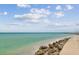 Scenic beach view with beautiful blue water and a rock seawall at 200 1St Ave # 406, St Pete Beach, FL 33706