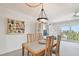 Cozy dining room with wood table and chairs, complemented by a stylish light fixture and beach-themed art at 200 1St Ave # 406, St Pete Beach, FL 33706
