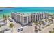 Exterior shot of a large condominium building with ample parking and beach access at 200 1St Ave # 406, St Pete Beach, FL 33706