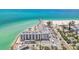Waterfront condominium building with a sandy beach and pier in the background at 200 1St Ave # 406, St Pete Beach, FL 33706