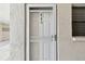 Image of unit 406 front door featuring a storm door and a window to the side at 200 1St Ave # 406, St Pete Beach, FL 33706