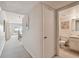 Hallway view of unit leading to living/dining area and a half bath at 200 1St Ave # 406, St Pete Beach, FL 33706