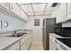 Compact kitchen with stainless steel appliances and tile flooring at 200 1St Ave # 406, St Pete Beach, FL 33706
