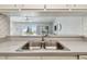 Pass-through kitchen showcasing sink, countertop, and view of the living room with balcony access at 200 1St Ave # 406, St Pete Beach, FL 33706