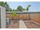 Fenced backyard space with wood mulch and sidewalk leading to the community at 2011 S Carolina Ave, Tampa, FL 33629