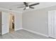 Bright bedroom with a ceiling fan, a window with blinds, gray walls, and light gray wood-look floors at 2011 S Carolina Ave, Tampa, FL 33629