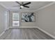 Bright bedroom with a ceiling fan, a window with blinds, gray walls, and light gray wood-look floors at 2011 S Carolina Ave, Tampa, FL 33629
