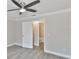Bright bedroom with a ceiling fan, a window with blinds, gray walls, and light gray wood-look floors at 2011 S Carolina Ave, Tampa, FL 33629