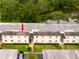 Aerial view of condominium building with lush landscaping and a serene lake in the background at 210 Cypress Ct # 122, Oldsmar, FL 34677