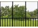 Enjoy serene views of lush greenery and a tranquil lake from the screened-in balcony at 210 Cypress Ct # 122, Oldsmar, FL 34677