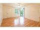 A cozy bedroom with a ceiling fan, wood floors, and sliding glass doors to a balcony at 210 Cypress Ct # 122, Oldsmar, FL 34677