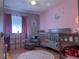 Cozy Bedroom with pink and grey decor, including crib and area rug at 210 Cypress Ct # 122, Oldsmar, FL 34677